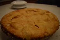 Close-up of a golden-brown crusted pie fresh from the oven, steam gently rising.