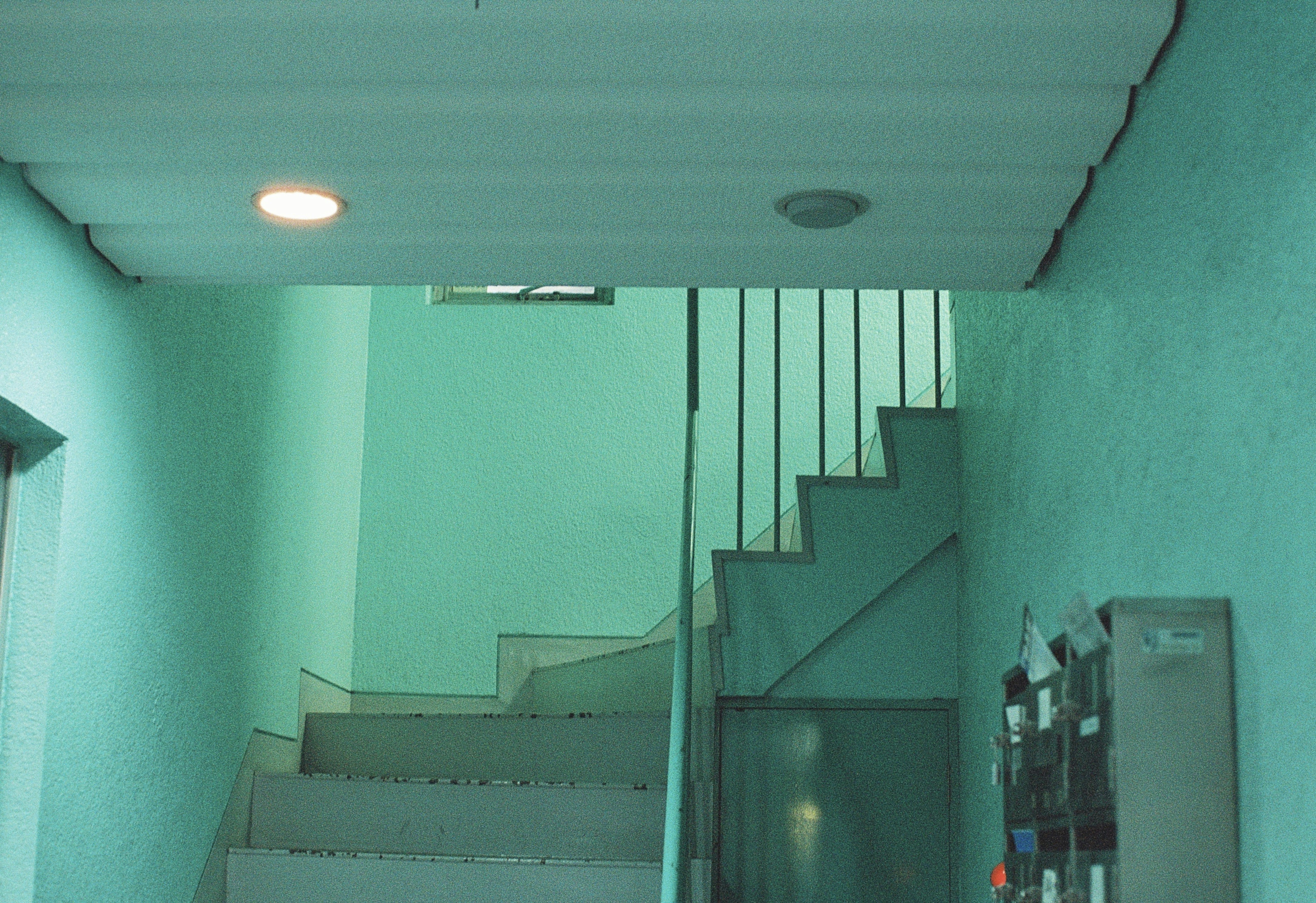a stairwell leading up to a door with a light on