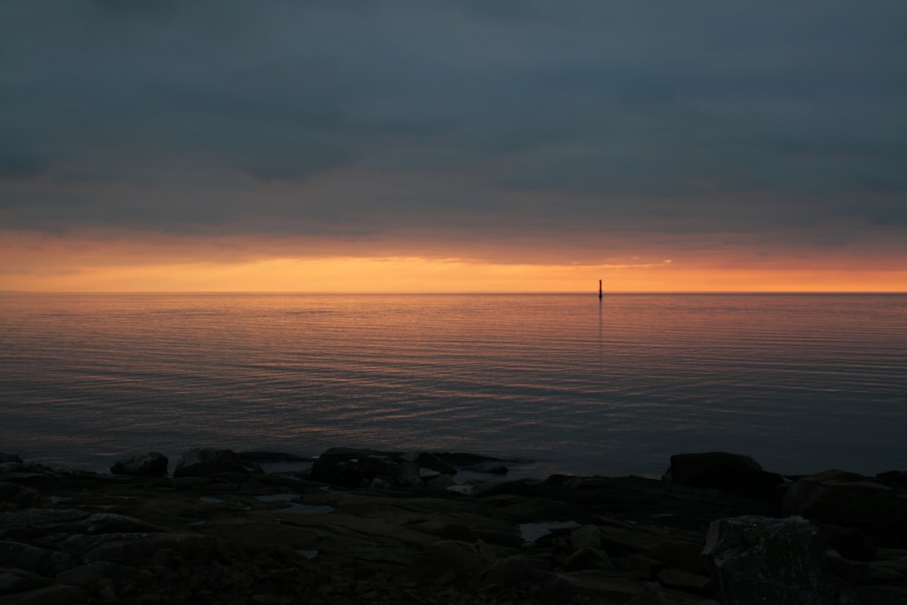 a large body of water sitting under a cloudy sky