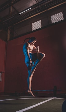 a man standing on one leg in a gym