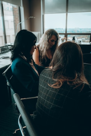 A professional woman discussing insurance options with clients in a modern office.