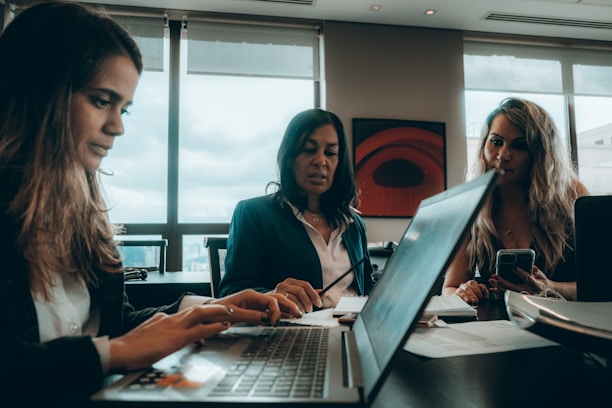 a group of women sitting around a laptop computer