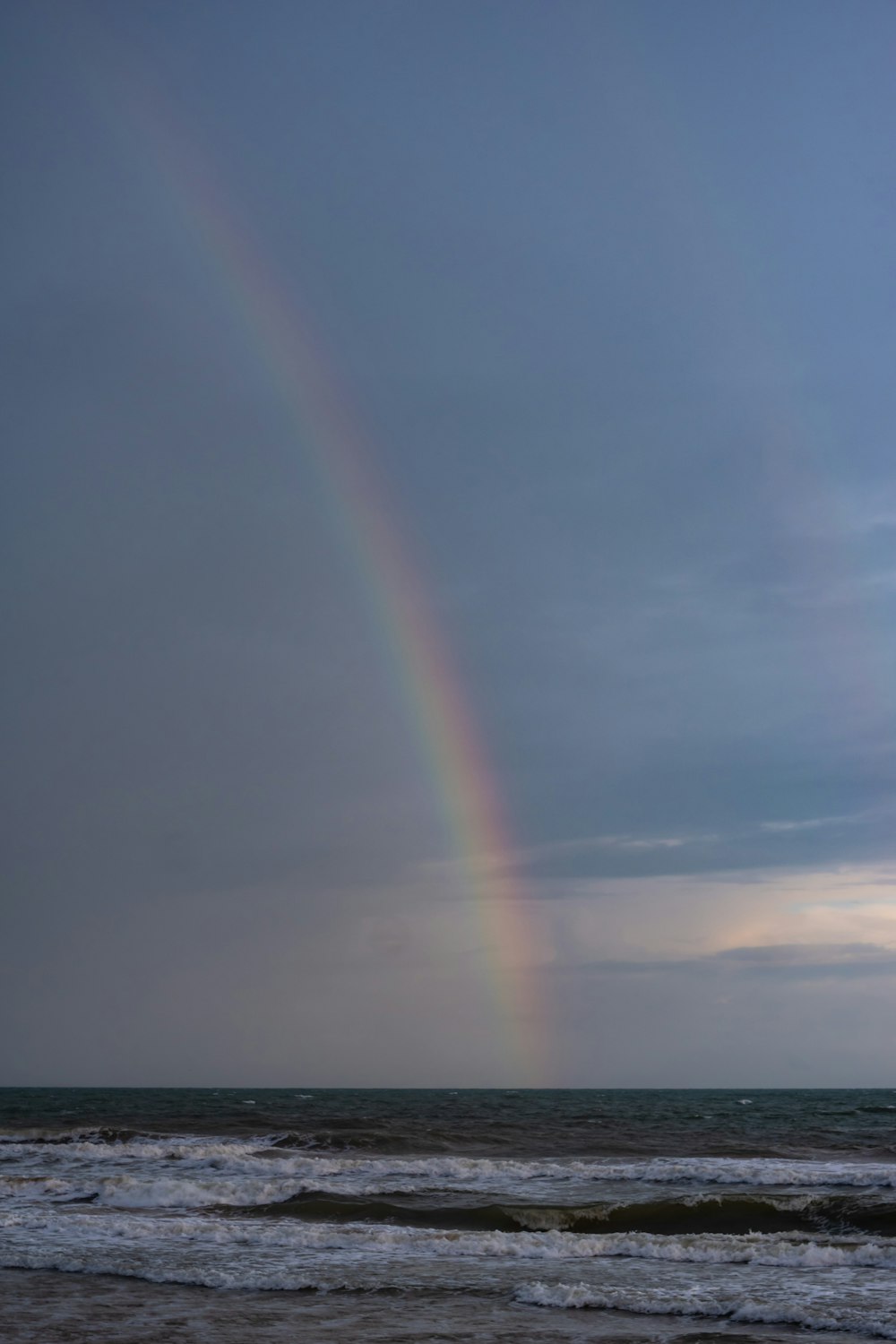 a rainbow in the sky over the ocean