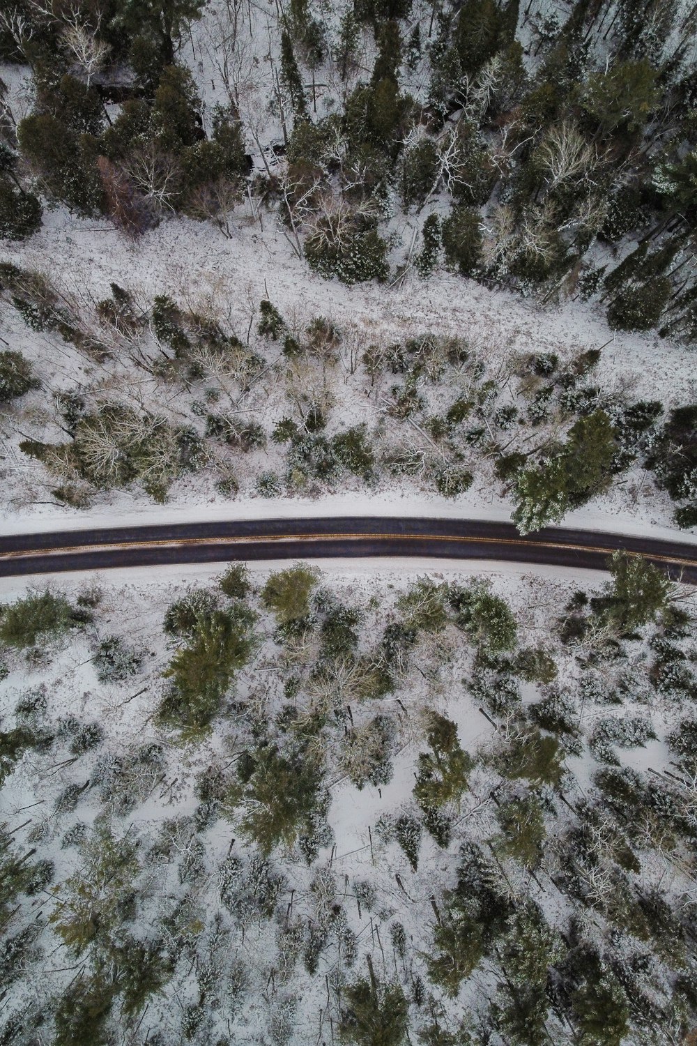 an aerial view of a road in the snow