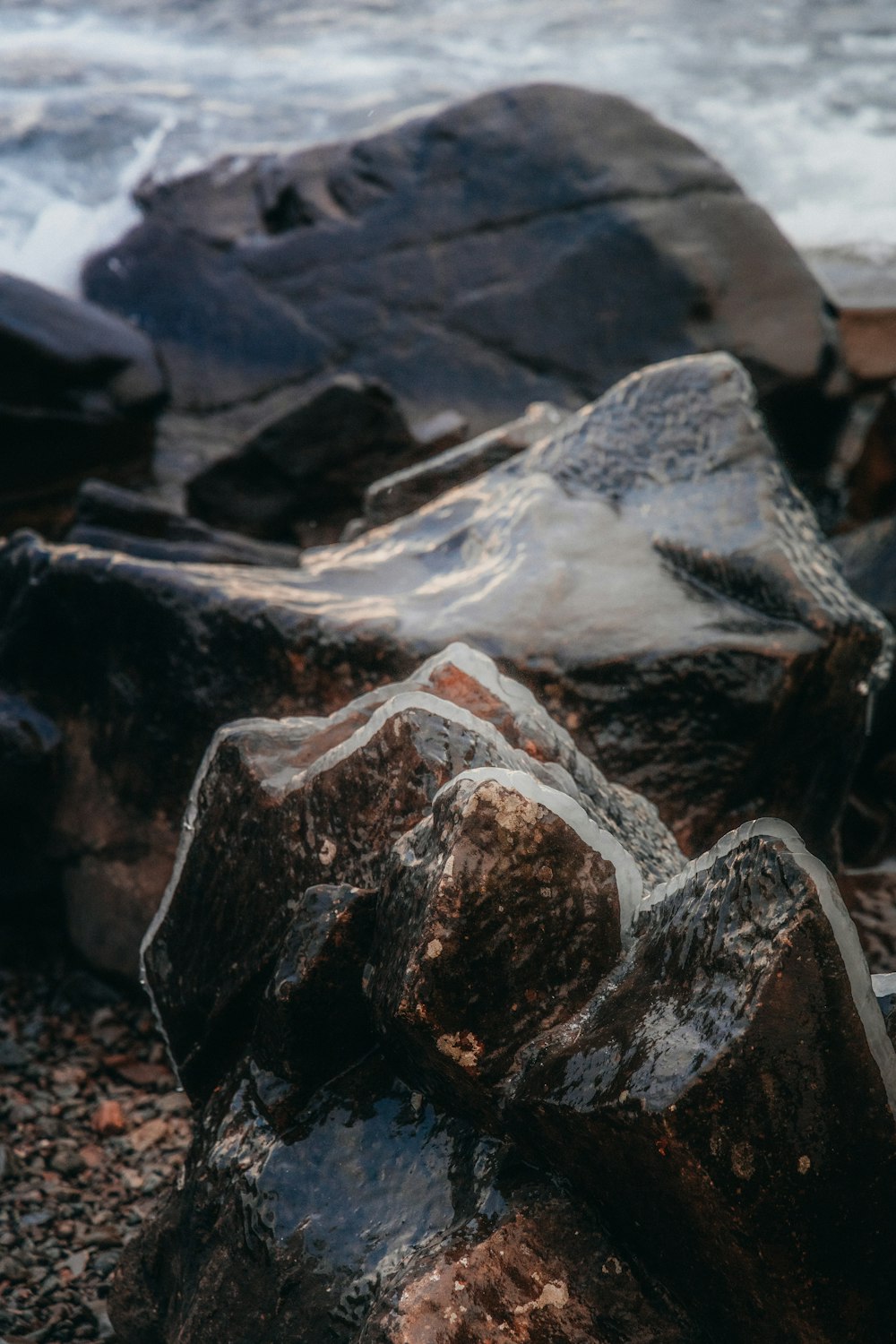 a close up of rocks on a beach near the ocean