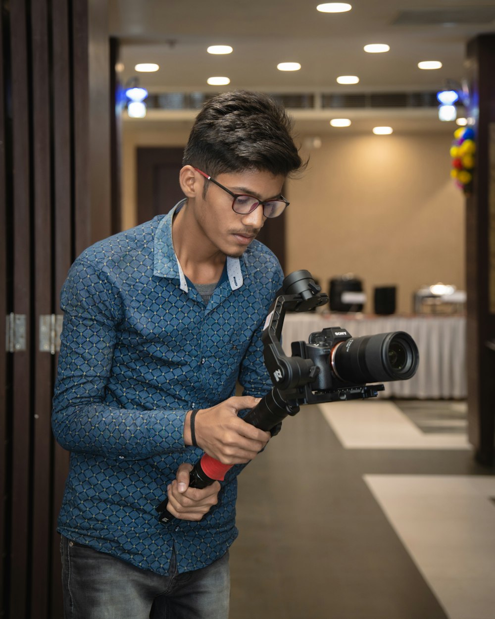 a man holding a camera and looking at it