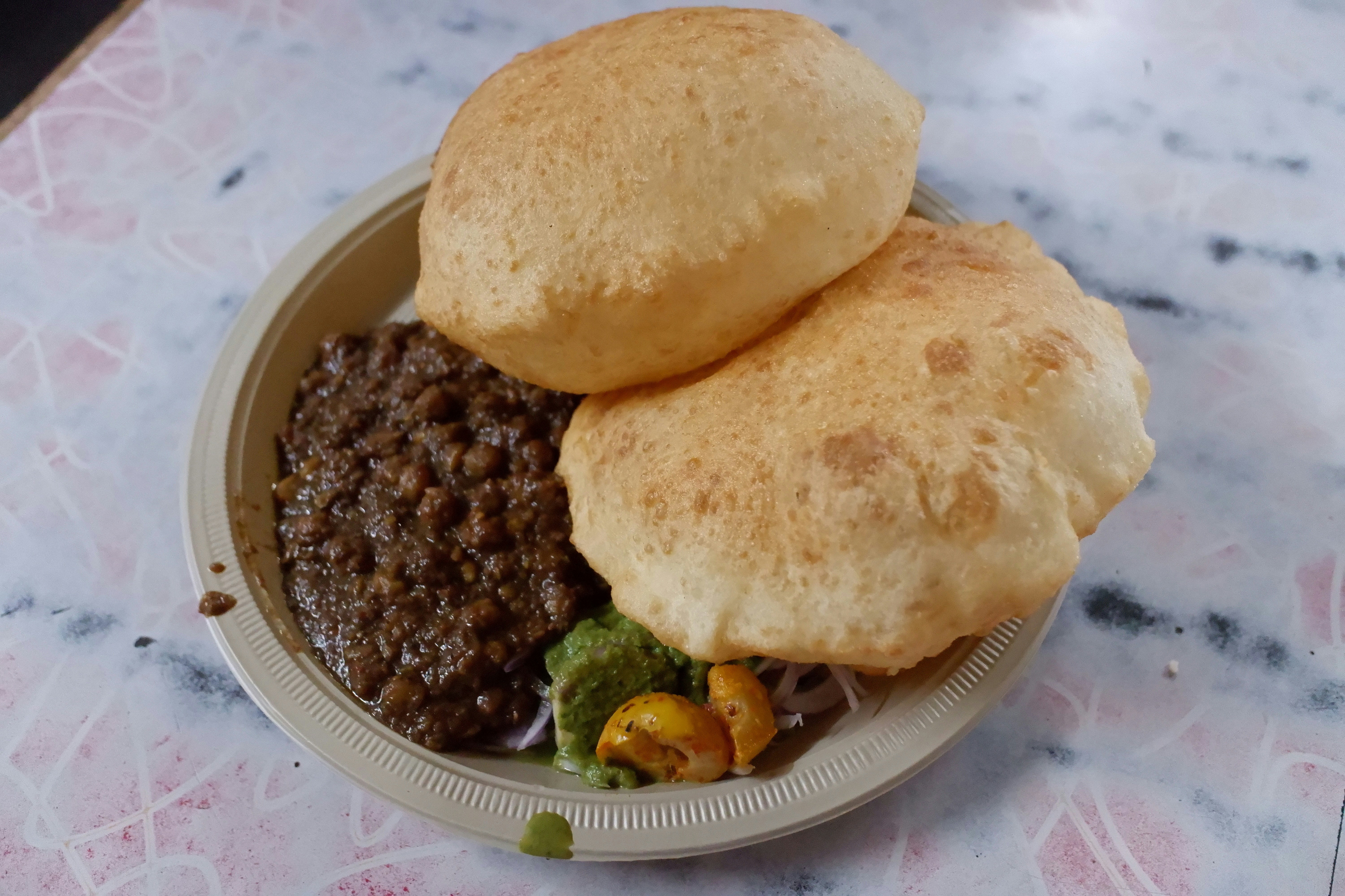 Golden deep fried puri bread served with spiced aloo sabji potato curry