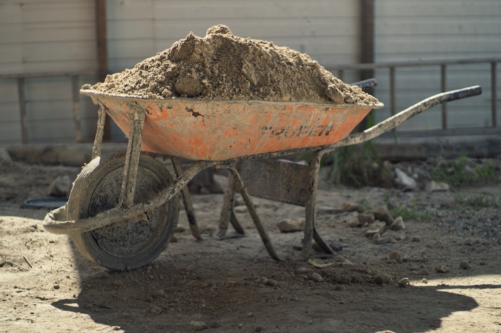 a wheelbarrow filled with dirt in front of a building