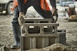 African woman adjusting her protective gloves on a construction site