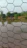 Close-up of galvanized wire mesh gabion being installed on a riverbank for erosion control.