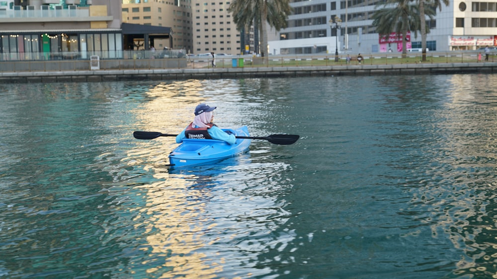 a person in a blue kayak on a body of water