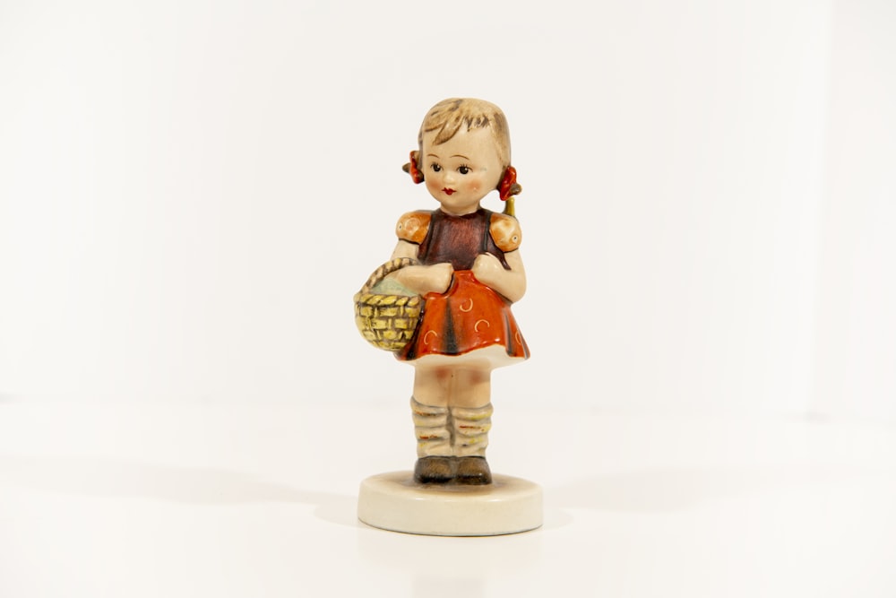 a figurine of a little girl holding a basket