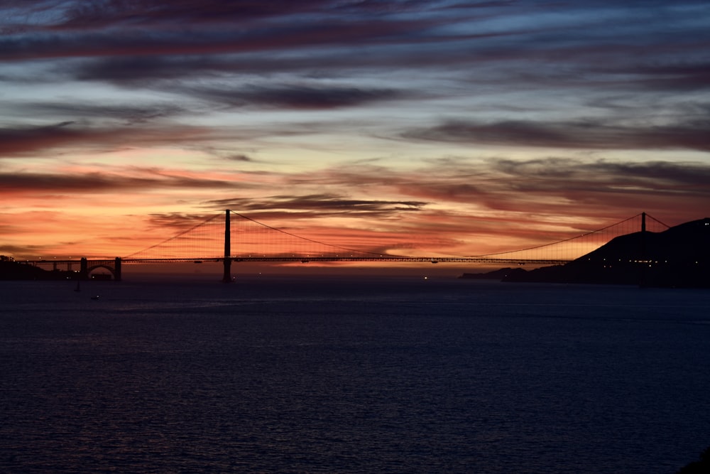 the sun is setting over the bay bridge