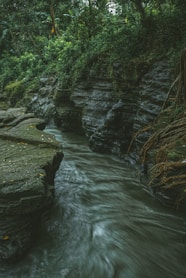a large waterfall over some water with Starved Rock State Park in the background