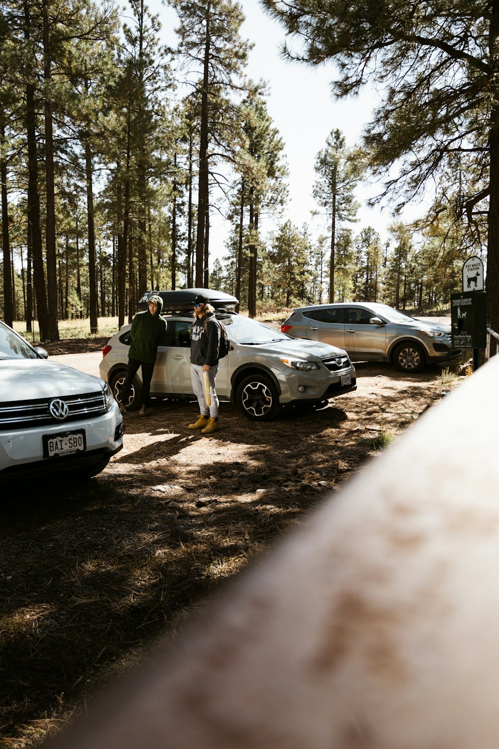 a group of people standing next to parked cars