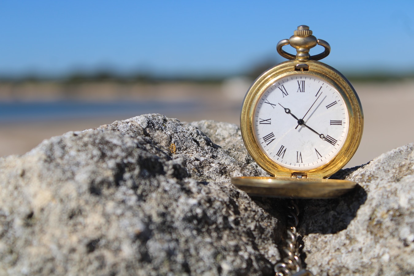 a pocket watch sitting on top of a rock
