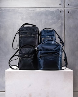 three pieces of luggage sitting on top of a white block