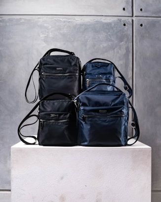 three pieces of luggage sitting on top of a white block