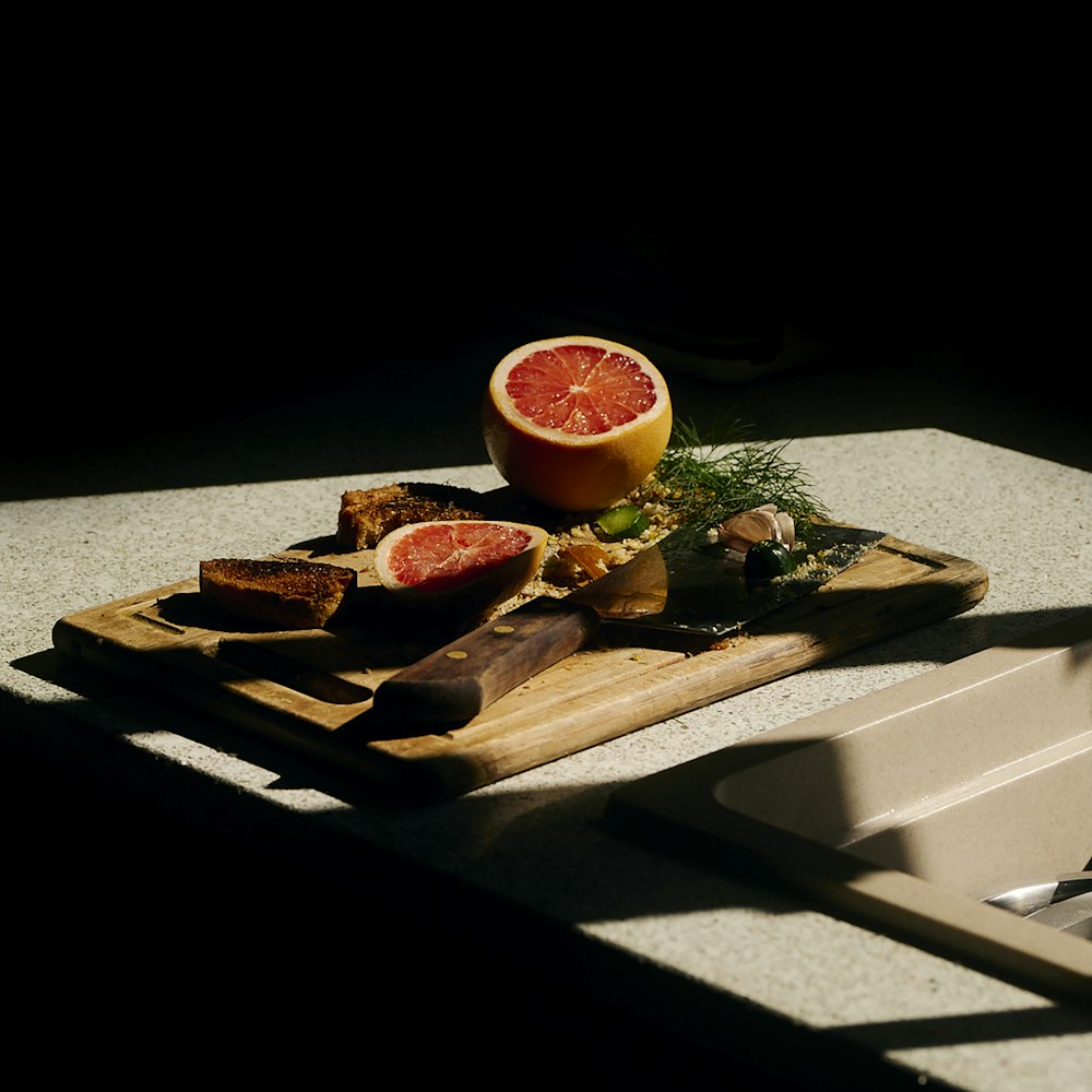 a cutting board with grapefruit and bread on it