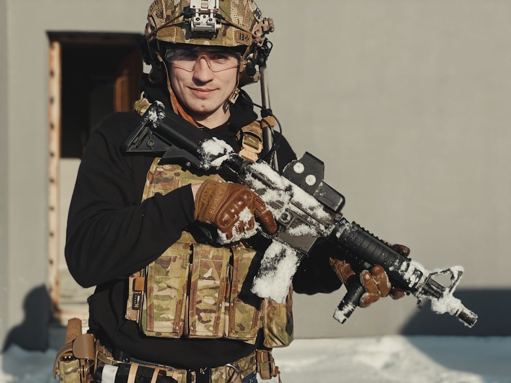 a man in camouflage holding a machine gun