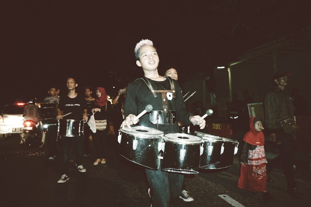 a group of people playing drums in the street