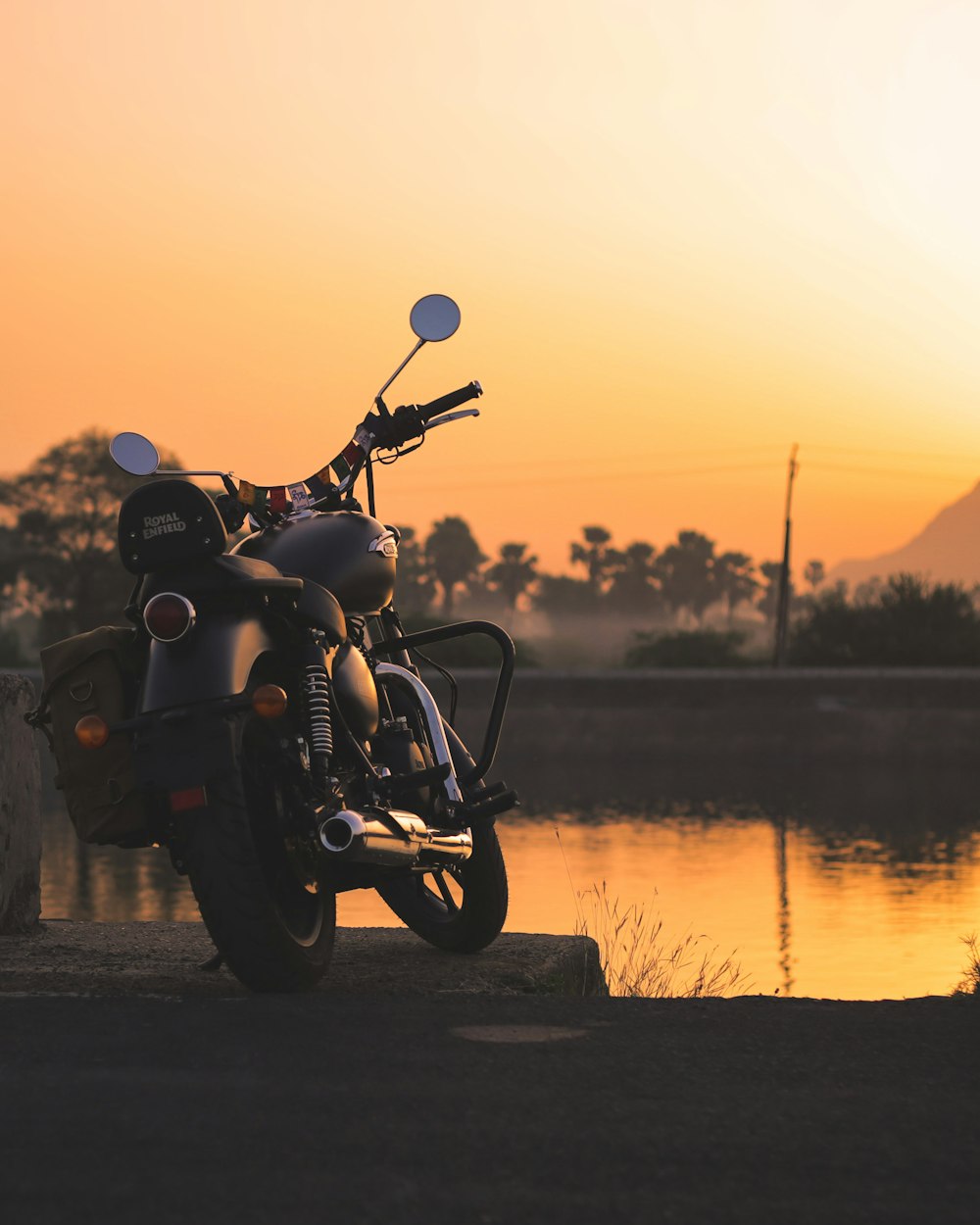 a motorcycle parked next to a body of water