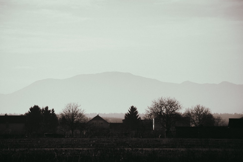 a black and white photo of a town with mountains in the background