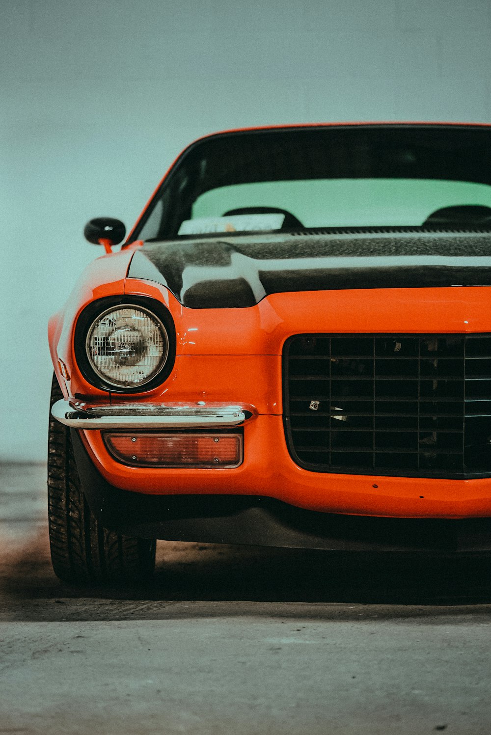 Un coche deportivo naranja aparcado en un garaje