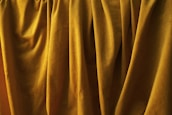 Close-up of luxurious curtain fabric textures in gold and dark blue tones, reflecting our elegant style.