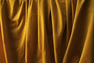 Golden curtains with folds and soft textures are prominently displayed, creating an impression of elegance and luxury.