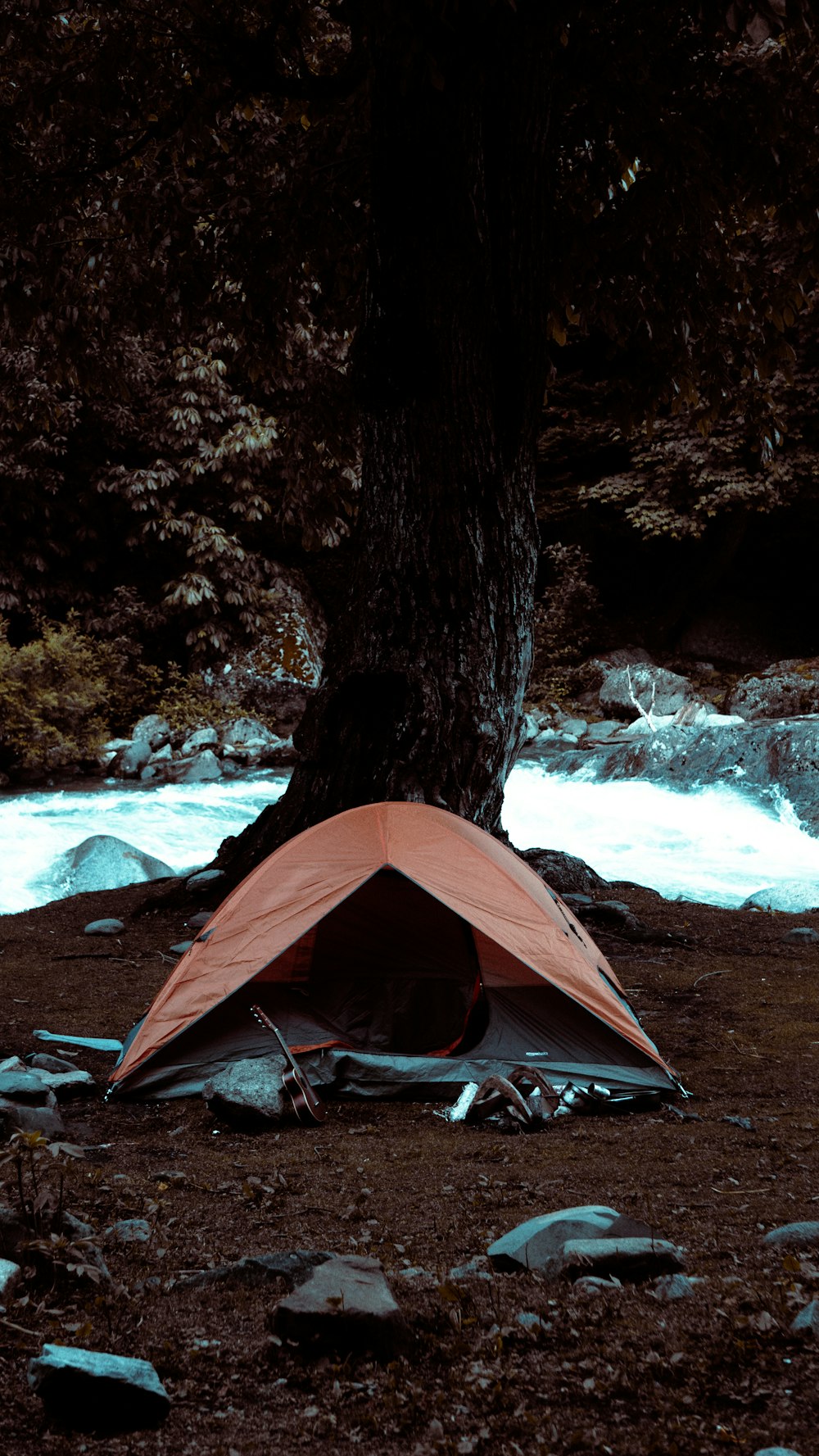 a tent pitched up next to a river