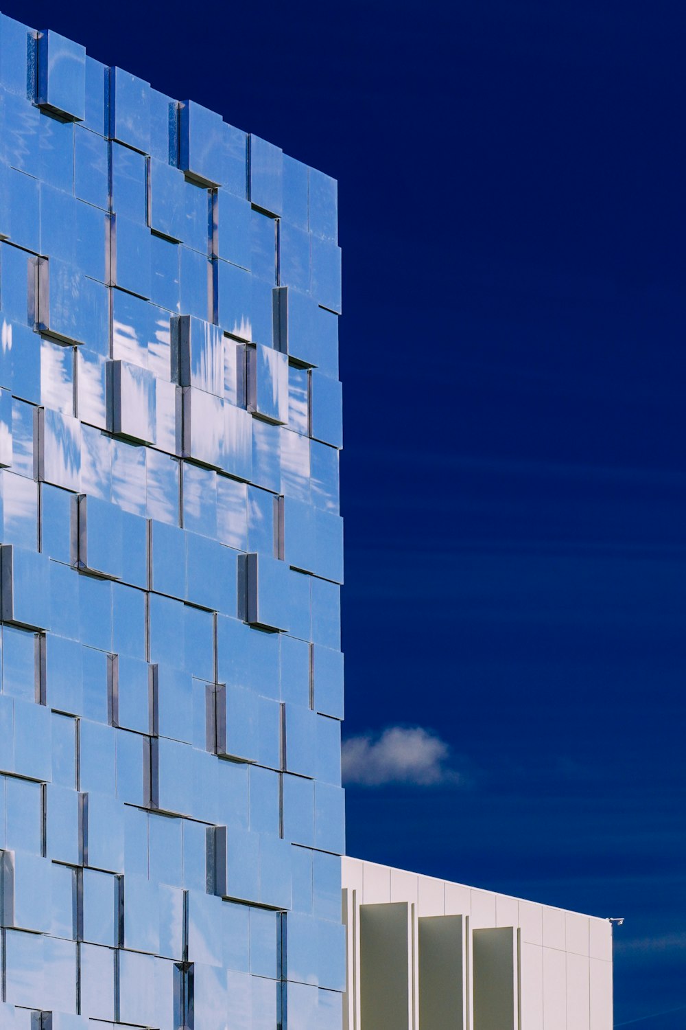 Un edificio azul alto con un fondo de cielo