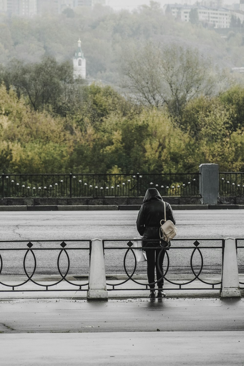 a person standing on a bridge with a backpack