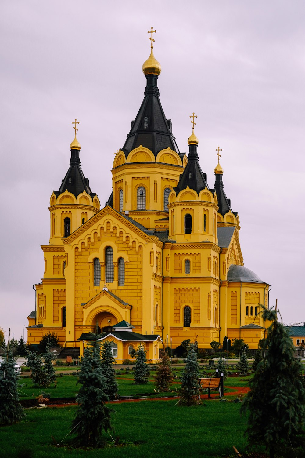 a large yellow building with a cross on top of it