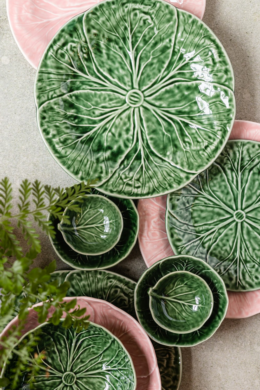 a table topped with plates and bowls filled with plants