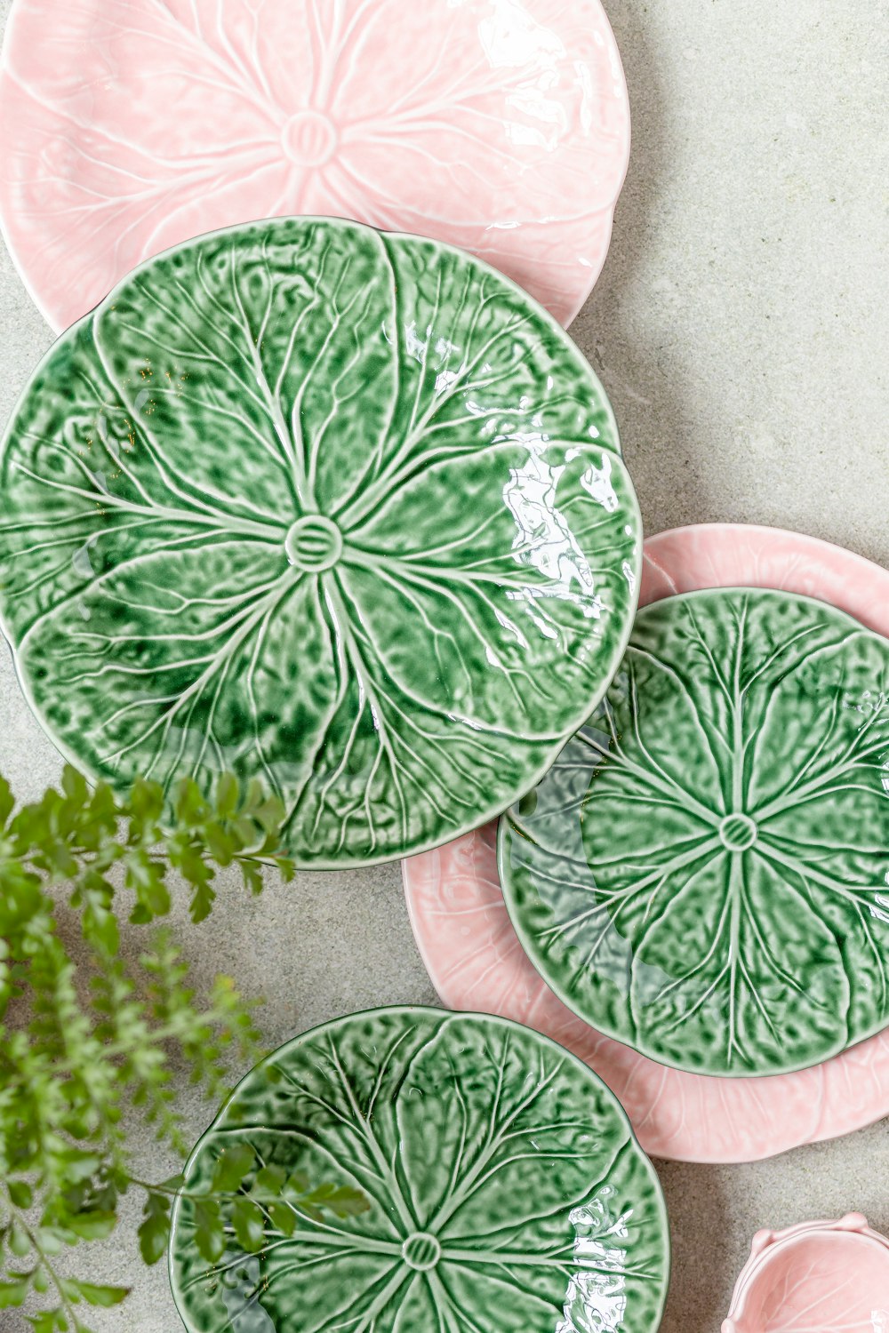 a group of green and pink plates sitting on top of a table