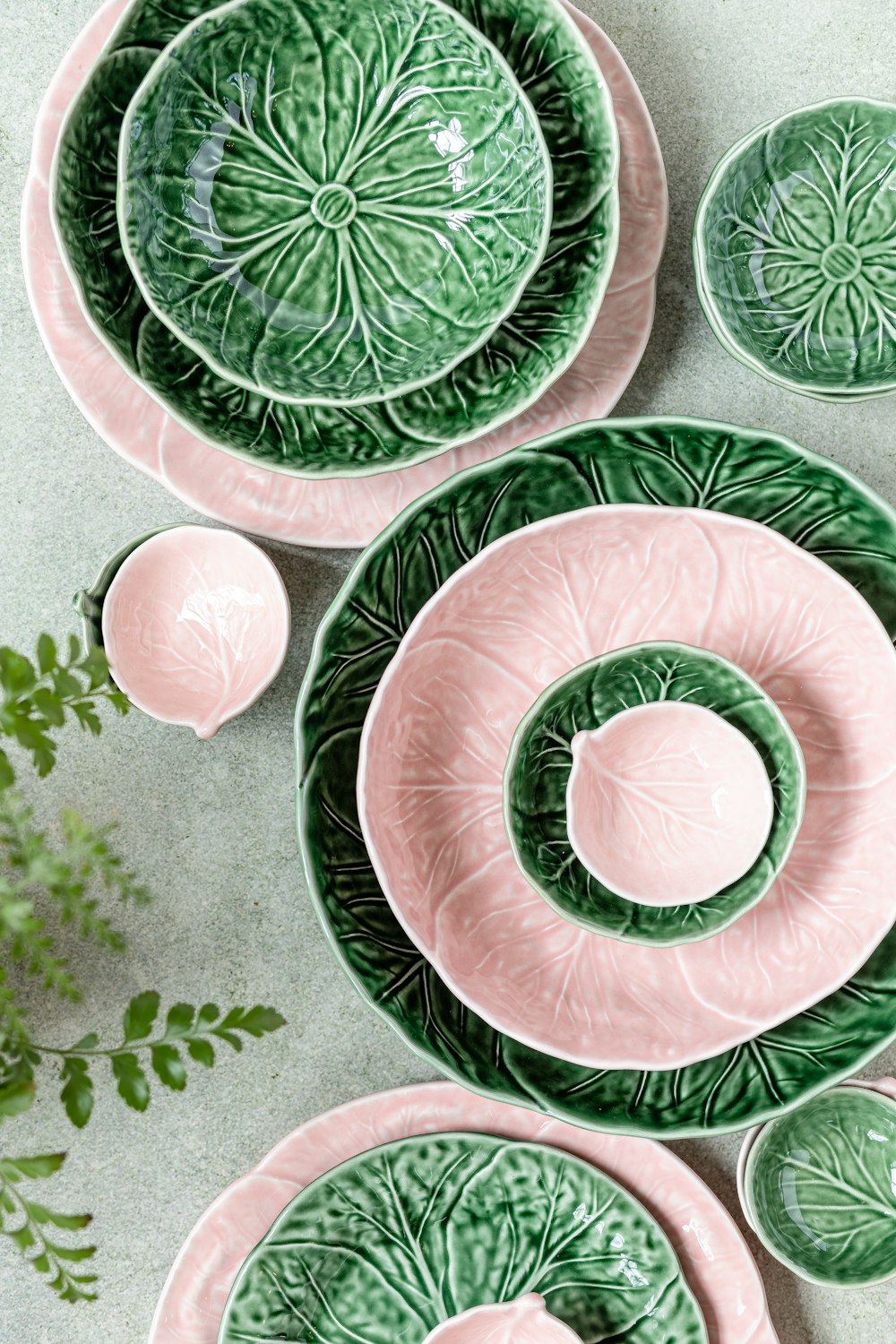 a group of green and pink plates and bowls