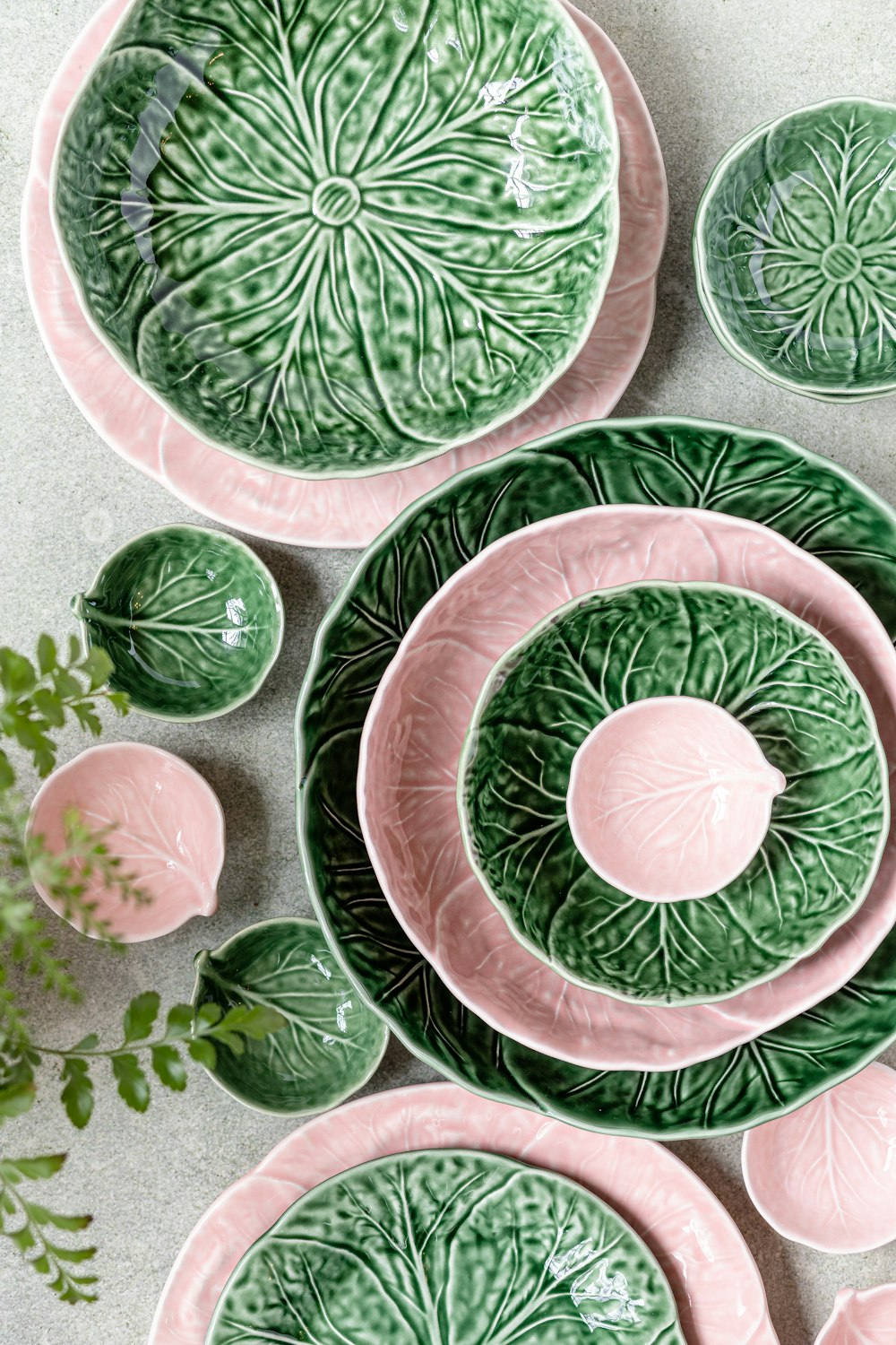 a collection of green and pink plates and bowls