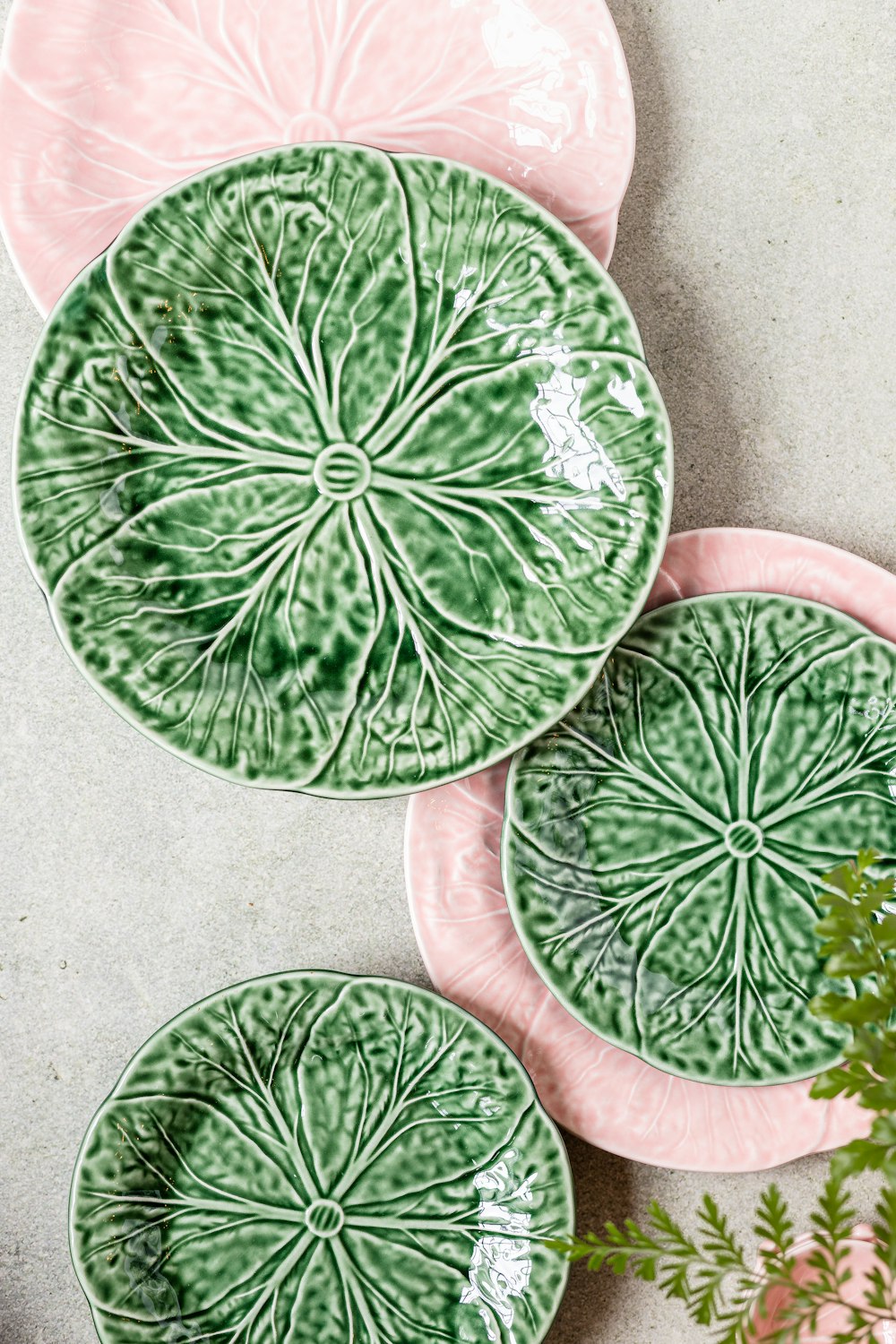 three green and pink plates sitting on top of a table