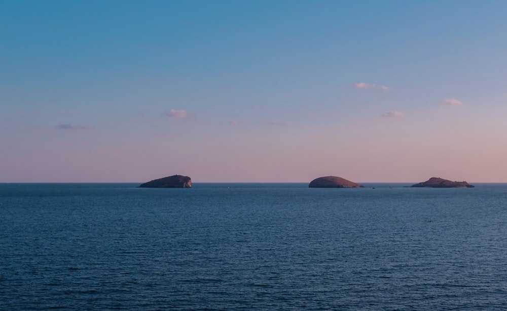 a body of water with two small islands in the distance