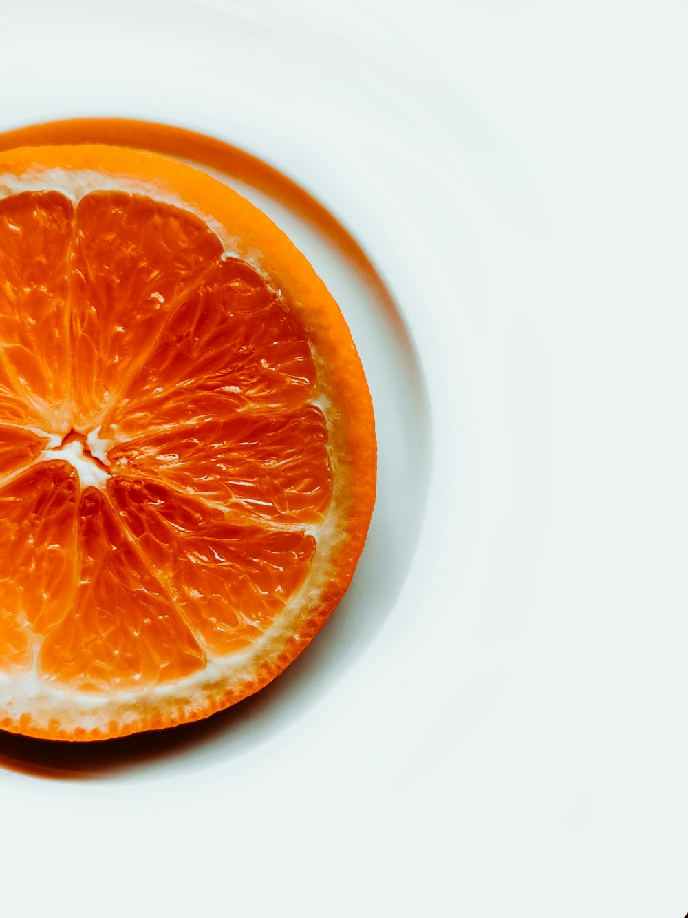 an orange cut in half on a white surface