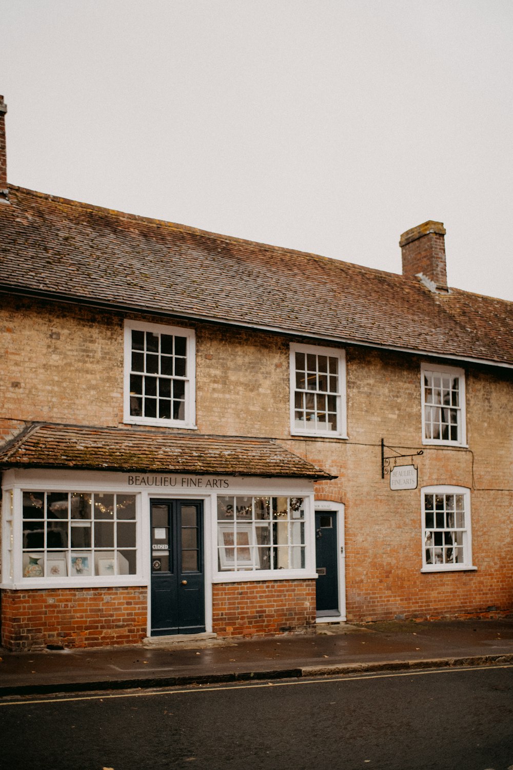 a brick building with a blue door and windows