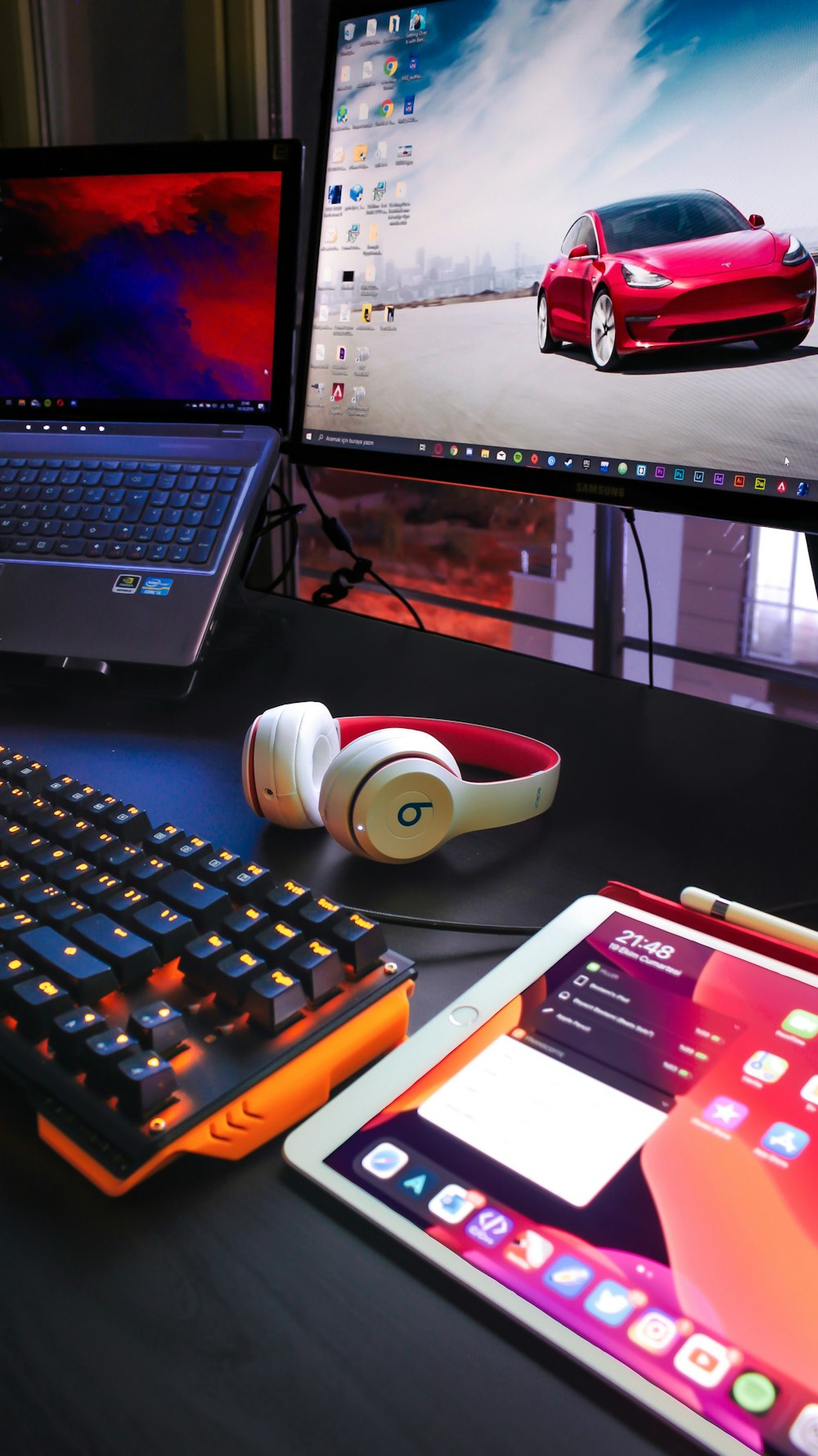 a laptop computer sitting on top of a desk next to a monitor