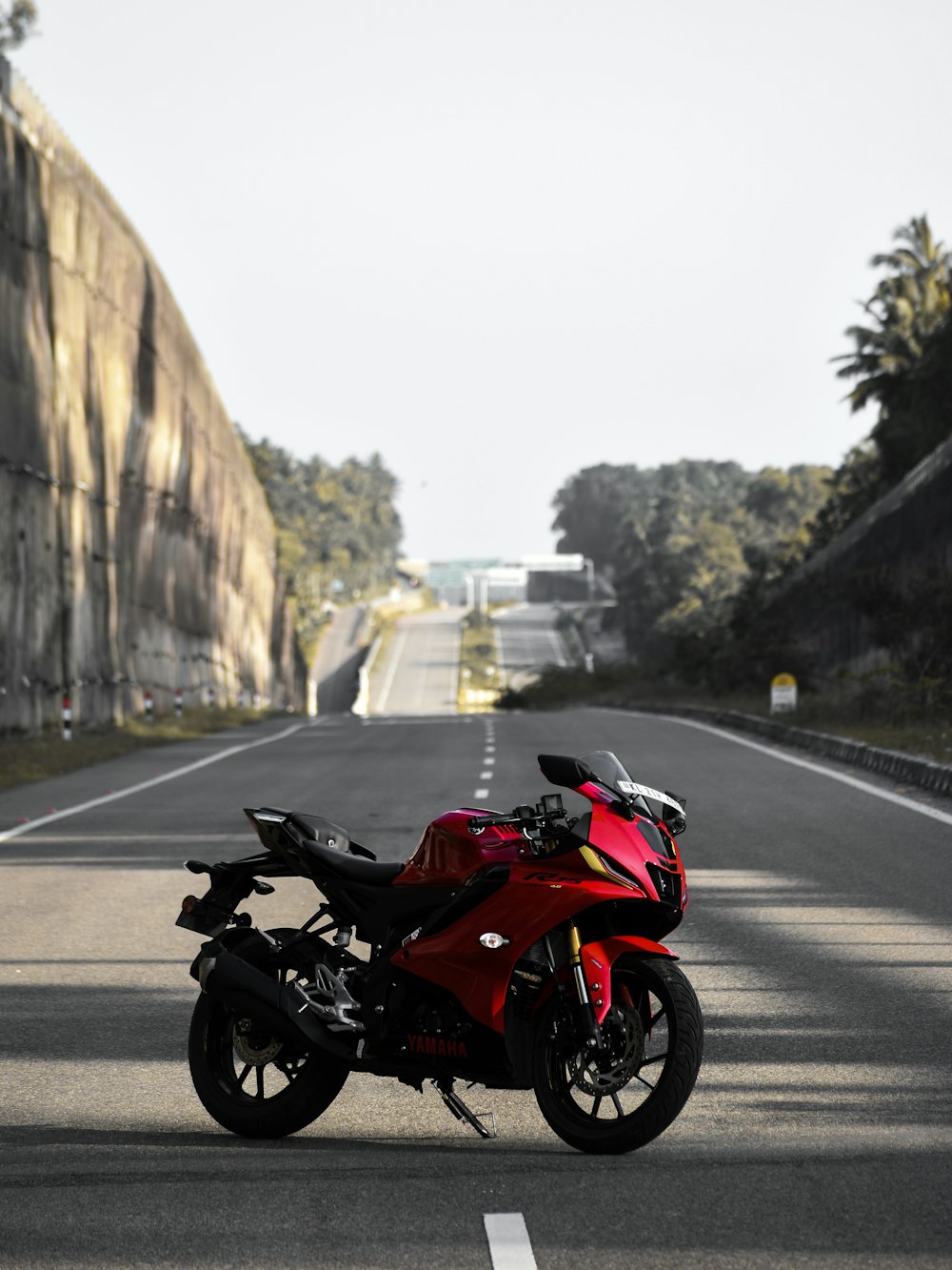 a red motorcycle parked on the side of a road