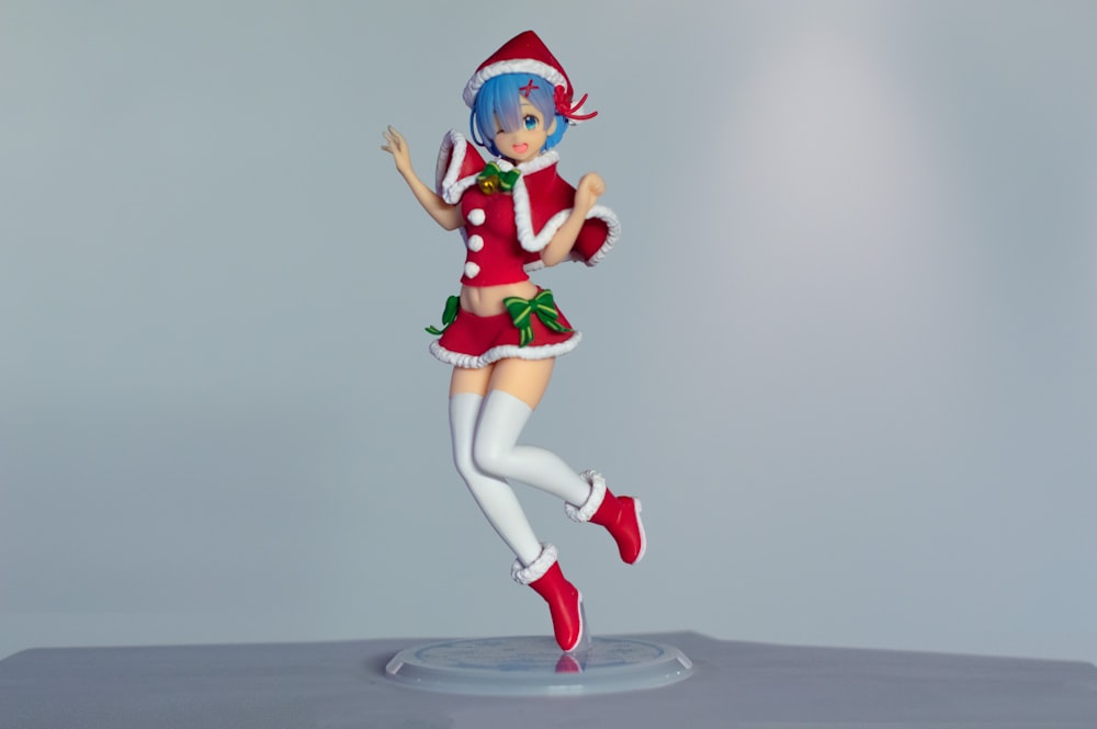 Une figurine d’une femme habillée en pom-pom girl de Noël