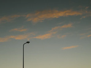 A minimalist still from a narrative film showing a quiet street at dusk with warm tones