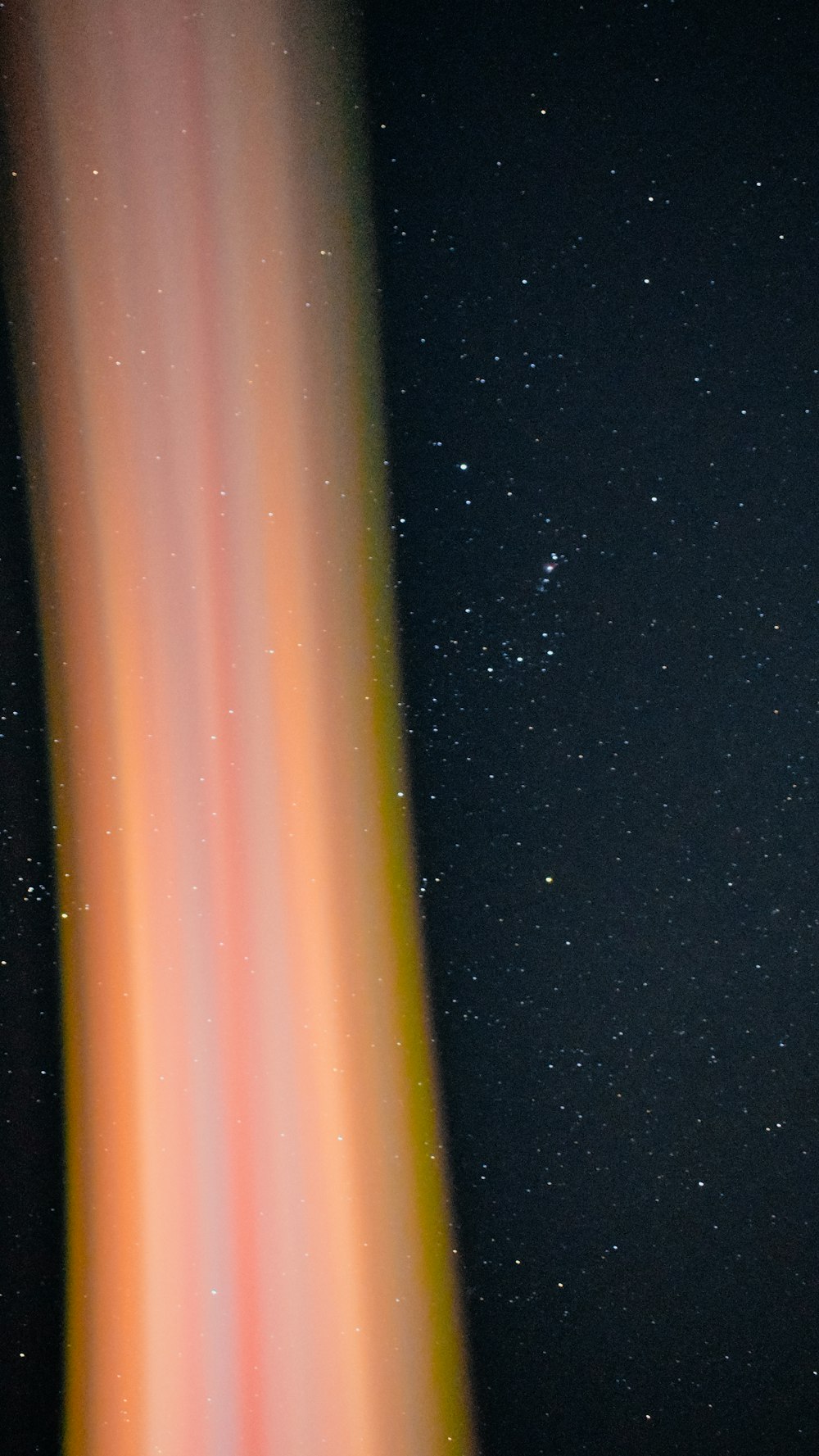 an orange and yellow streak in the night sky