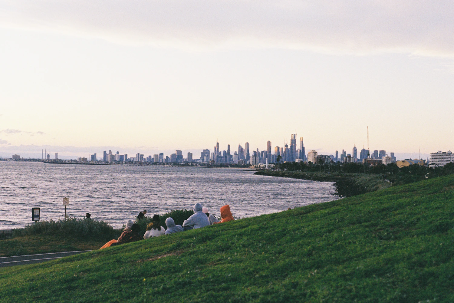 From the grassy slopes of Point Ormond, the city skyline sits to the north across the bay, and the view holds its colour into the afterglow.