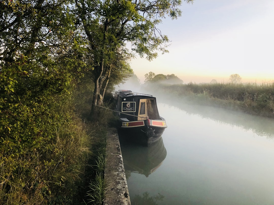 a train traveling down tracks next to a body of water,