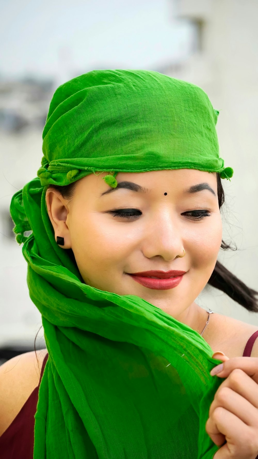 Una donna con una sciarpa verde intorno alla testa